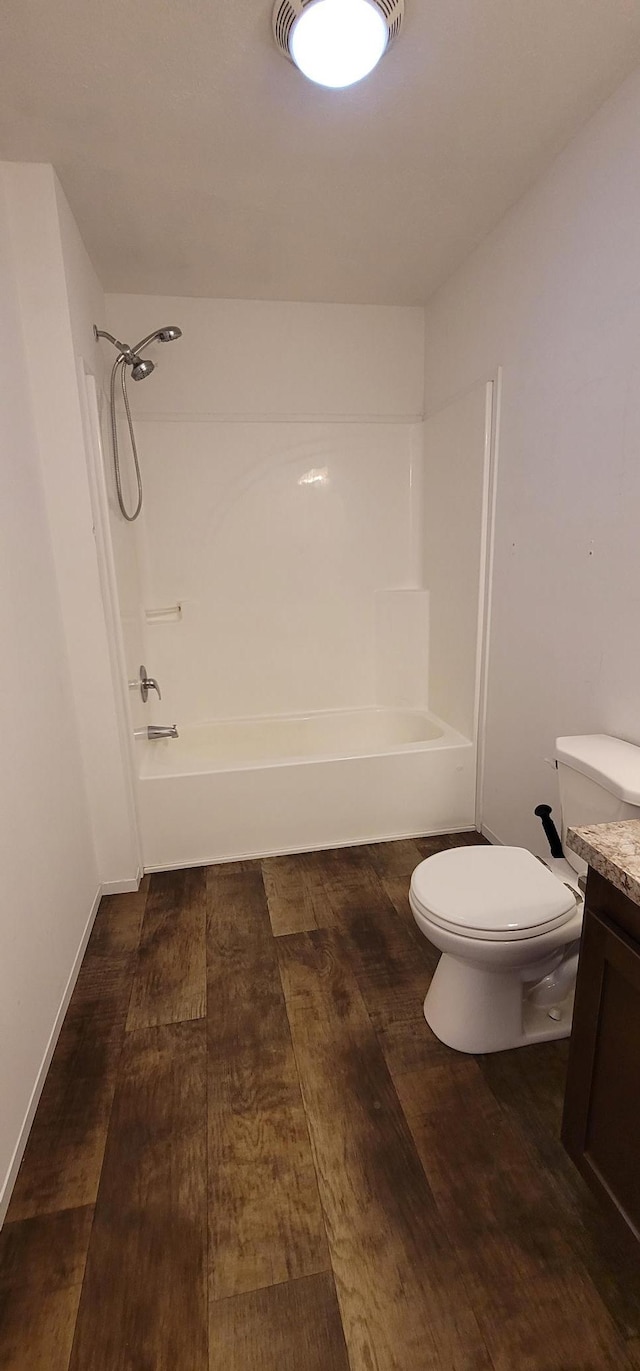 bathroom with toilet, vanity, hardwood / wood-style floors, and shower / bathtub combination