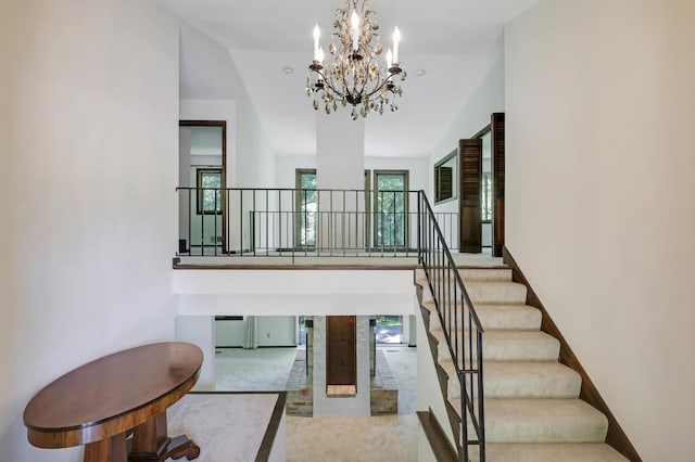 stairway featuring high vaulted ceiling, carpet floors, and an inviting chandelier