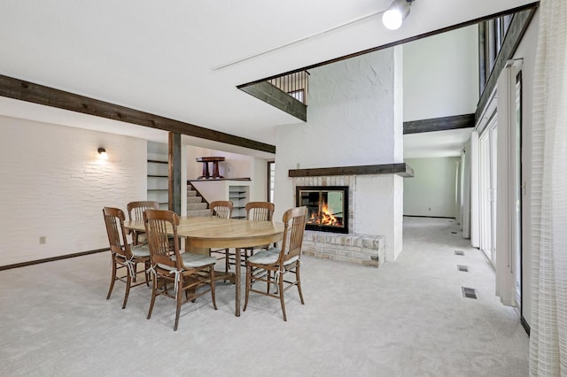 dining room with light carpet and a fireplace