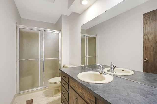 bathroom featuring vanity, toilet, and a shower with shower door