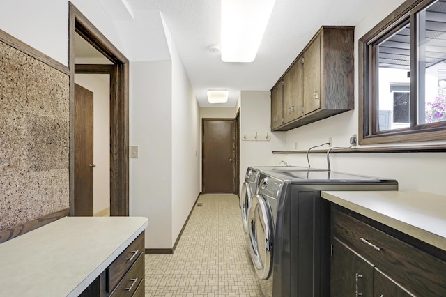 laundry room featuring washer and dryer and cabinets