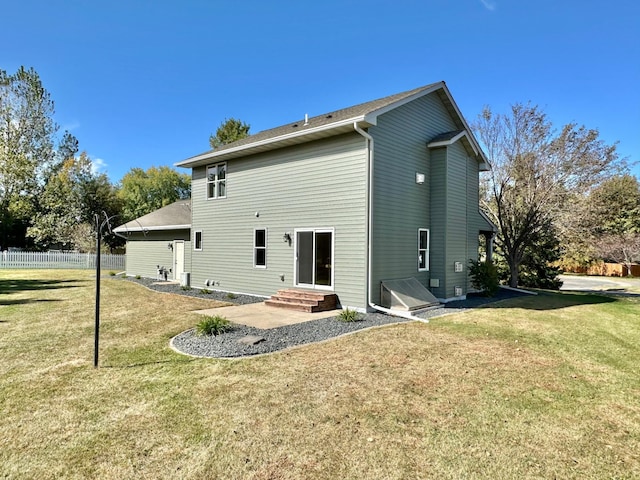 rear view of property featuring a lawn