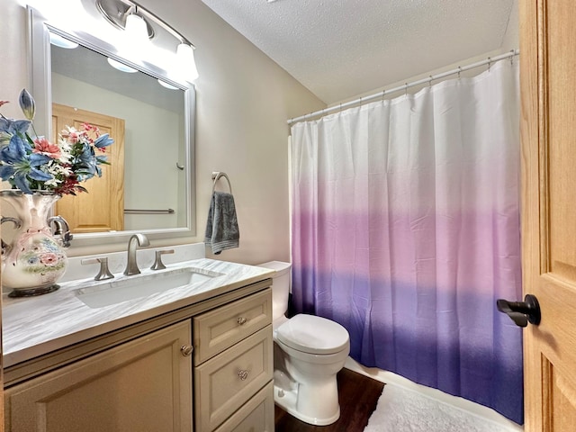 bathroom with a shower with curtain, vanity, a textured ceiling, hardwood / wood-style floors, and toilet