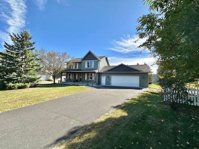 view of front of house with covered porch, a garage, and a front yard