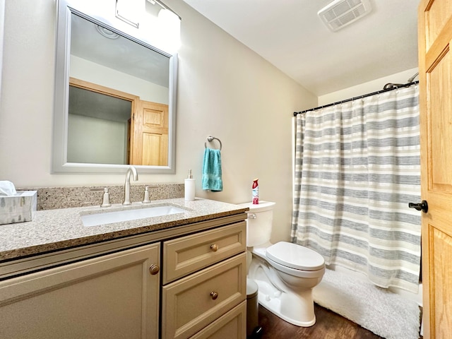 bathroom with wood-type flooring, vanity, toilet, and walk in shower