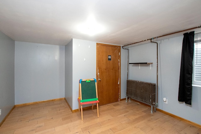 empty room featuring light wood-type flooring and radiator