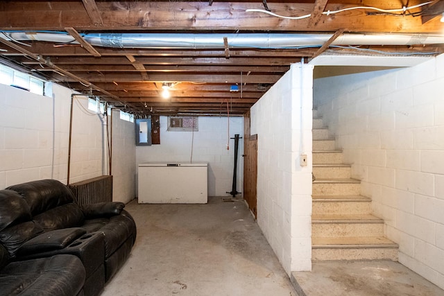 basement with electric panel and refrigerator