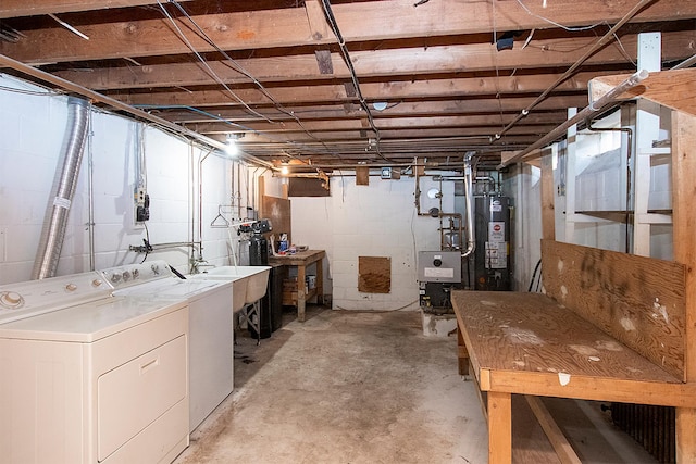 basement featuring washer and dryer, gas water heater, and sink