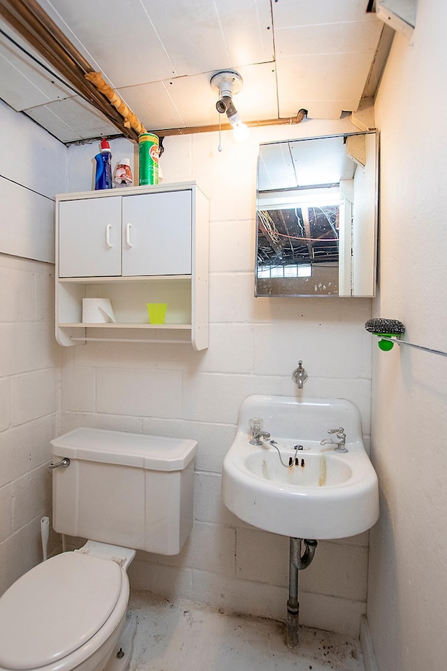 bathroom with concrete floors and toilet