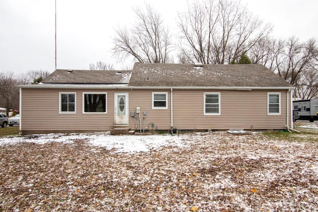 view of snow covered rear of property