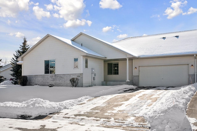 single story home featuring a garage and brick siding