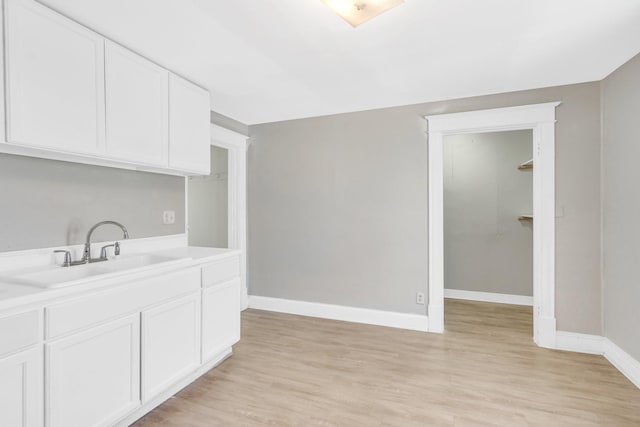 kitchen featuring white cabinetry, light hardwood / wood-style floors, and sink