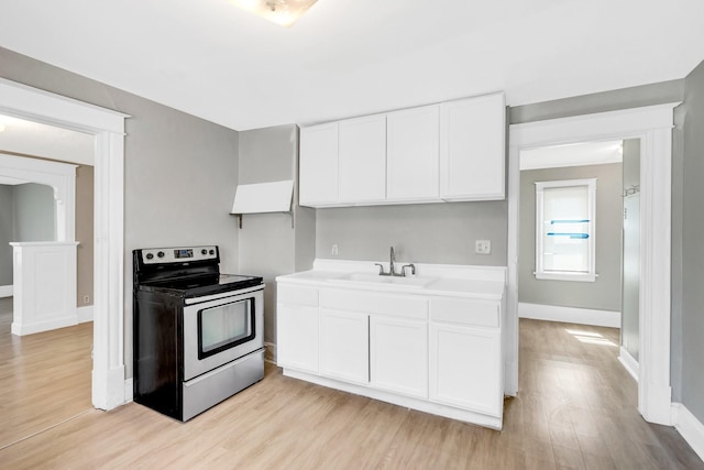 kitchen featuring light hardwood / wood-style flooring, white cabinets, stainless steel range with electric stovetop, and sink