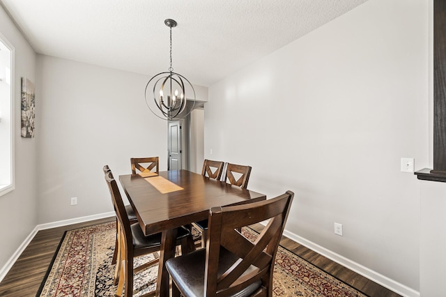 dining space featuring an inviting chandelier, hardwood / wood-style floors, and a textured ceiling