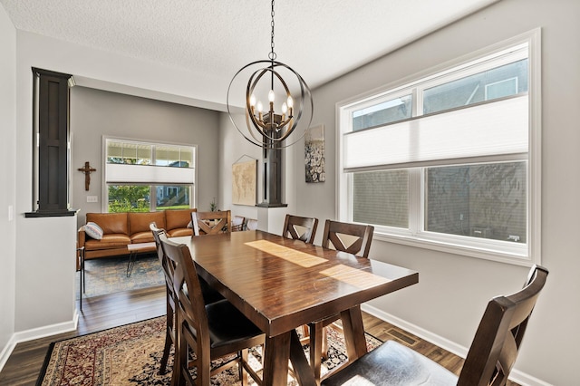 dining space with a textured ceiling, dark hardwood / wood-style flooring, and a wealth of natural light