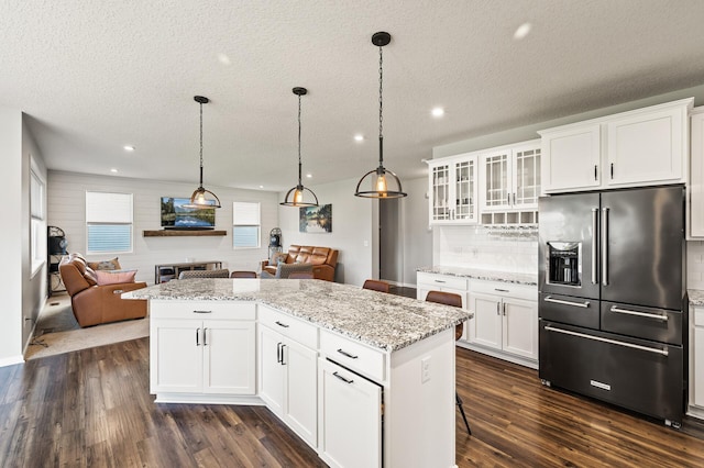 kitchen featuring white cabinets, a textured ceiling, high quality fridge, and dark hardwood / wood-style flooring