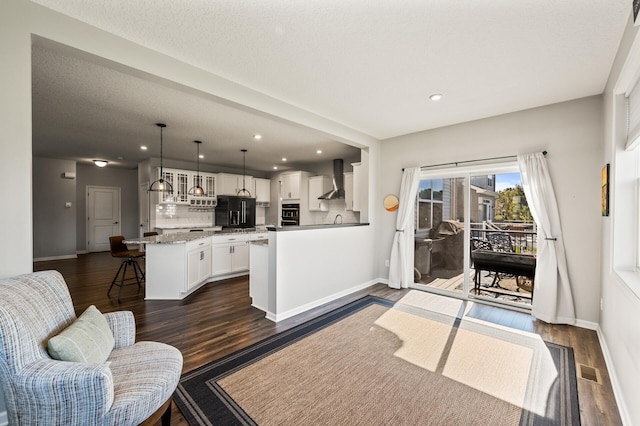 living room with a textured ceiling and dark wood-type flooring