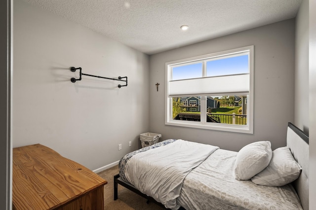 bedroom with a textured ceiling and carpet flooring