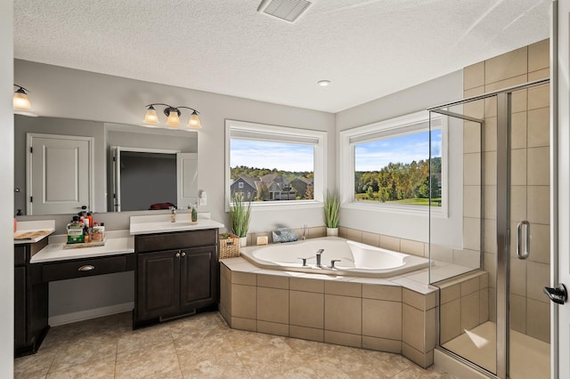 bathroom with a textured ceiling, tile patterned flooring, vanity, and separate shower and tub