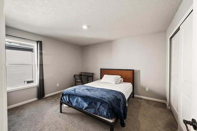 carpeted bedroom featuring a textured ceiling and a closet