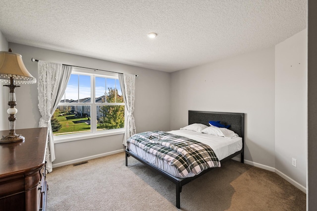 bedroom with a textured ceiling and carpet