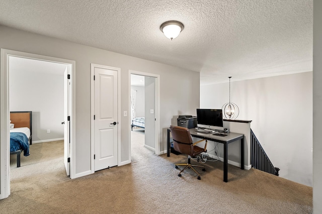 office with a textured ceiling and carpet flooring