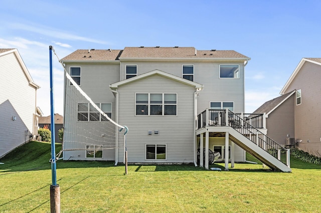 rear view of house featuring a deck and a yard