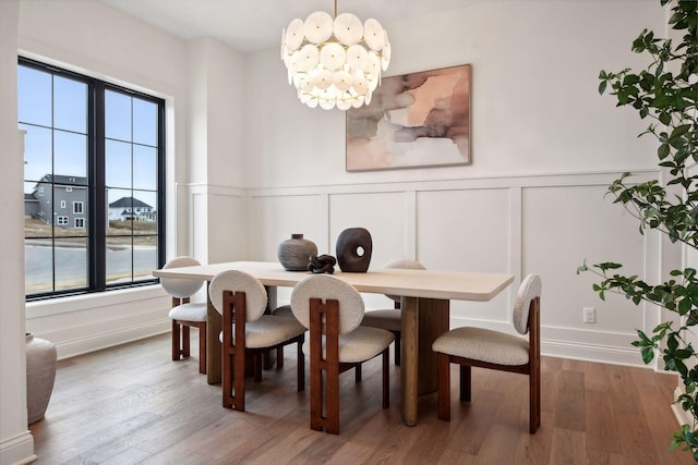 dining room with a notable chandelier, hardwood / wood-style floors, and a healthy amount of sunlight