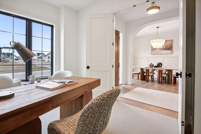 office area with an inviting chandelier and light hardwood / wood-style floors