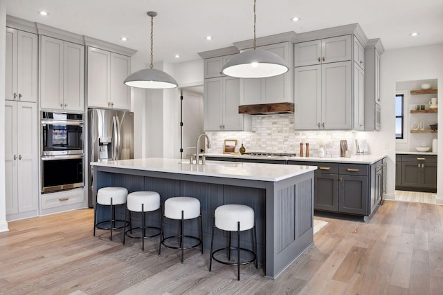 kitchen with gray cabinetry, light hardwood / wood-style floors, and pendant lighting