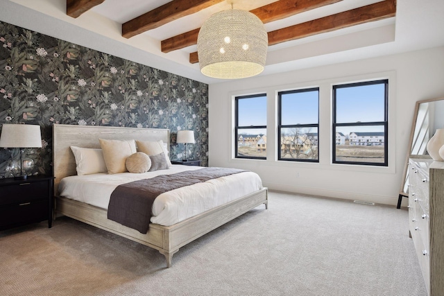 carpeted bedroom with beamed ceiling