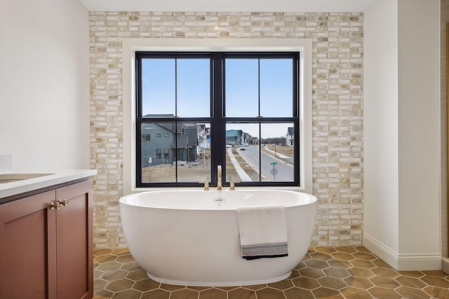 bathroom featuring tile walls, tile patterned flooring, vanity, and a washtub