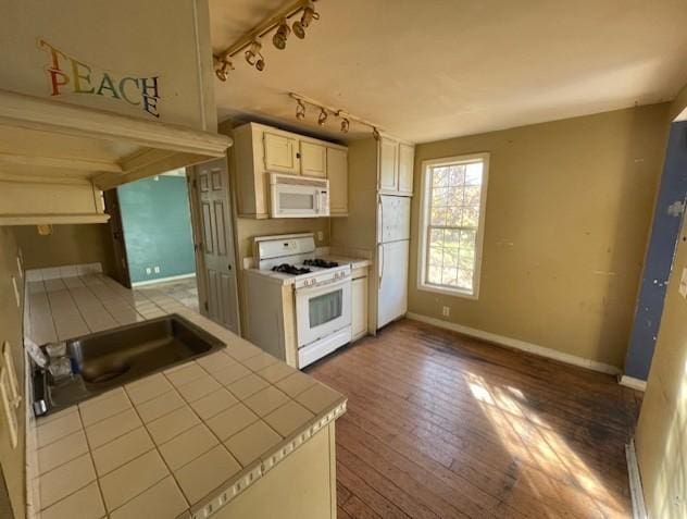 kitchen with tile countertops, wood-type flooring, sink, rail lighting, and white appliances