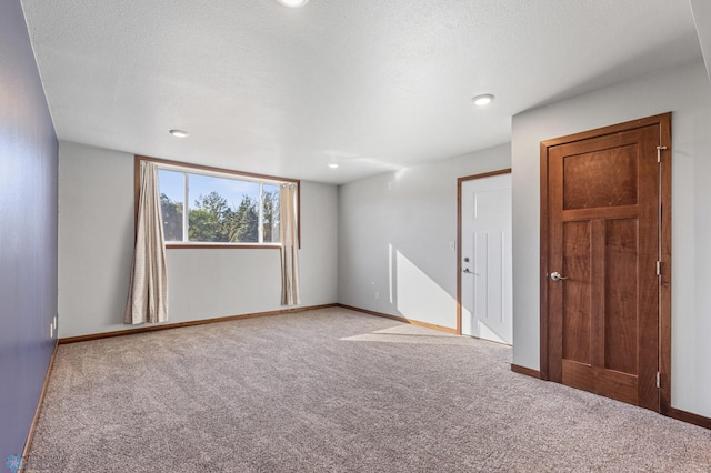 carpeted spare room with a textured ceiling