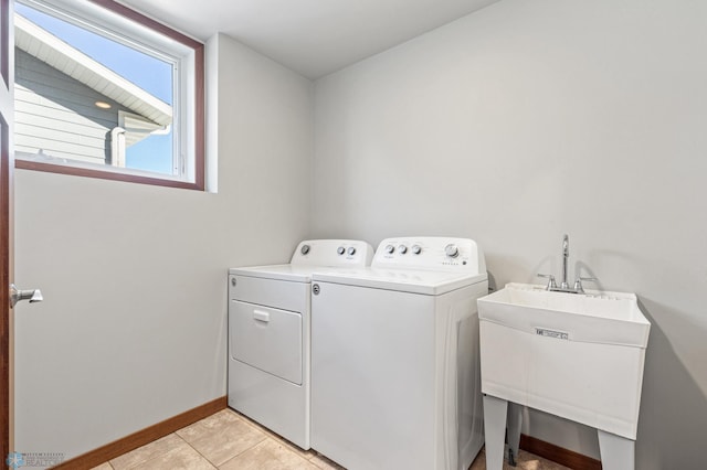 clothes washing area with washer and clothes dryer, sink, and light tile patterned floors