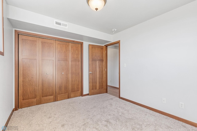 unfurnished bedroom with carpet, visible vents, a closet, and baseboards
