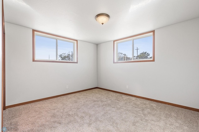 unfurnished room featuring carpet floors and baseboards