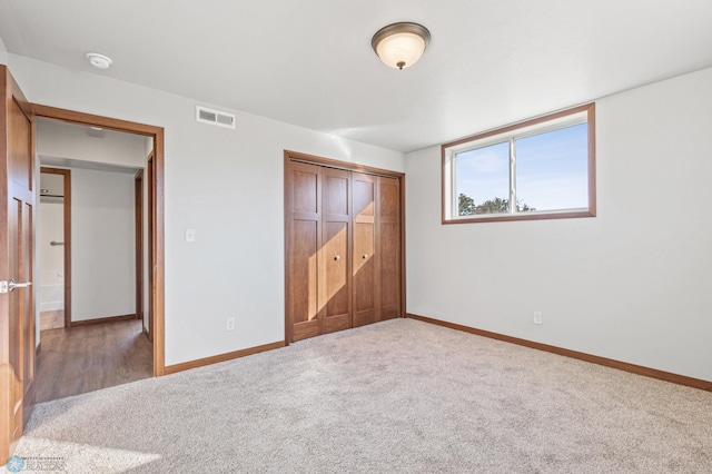 unfurnished bedroom with a closet and carpet flooring