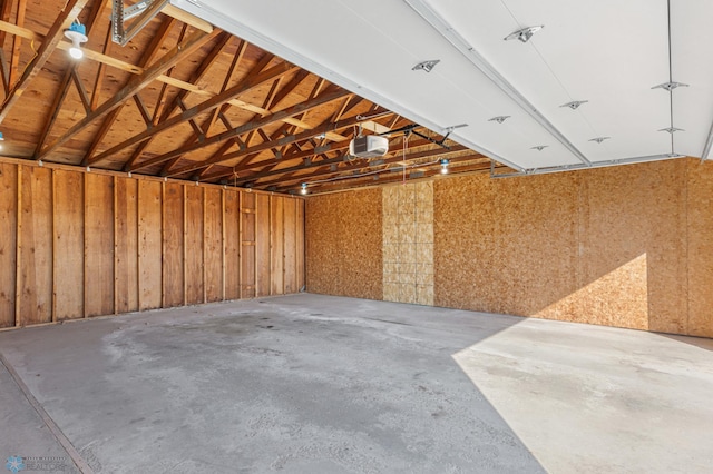 garage with wooden walls and a garage door opener