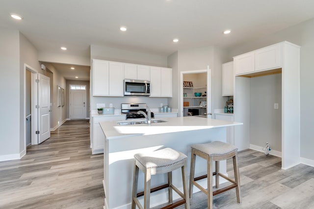 kitchen featuring white cabinetry, sink, an island with sink, and appliances with stainless steel finishes