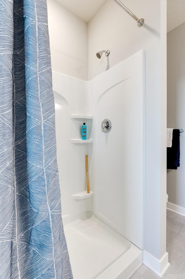 bathroom featuring a textured ceiling and walk in shower