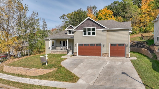 view of front of house featuring a porch, a garage, and a front lawn