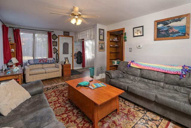 living room with ceiling fan and dark wood-type flooring