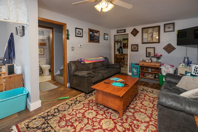 living room with ceiling fan and dark wood-type flooring