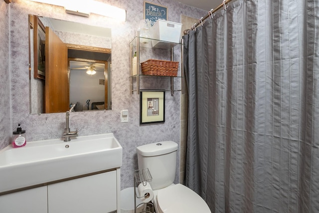 bathroom with ceiling fan, walk in shower, vanity, and toilet