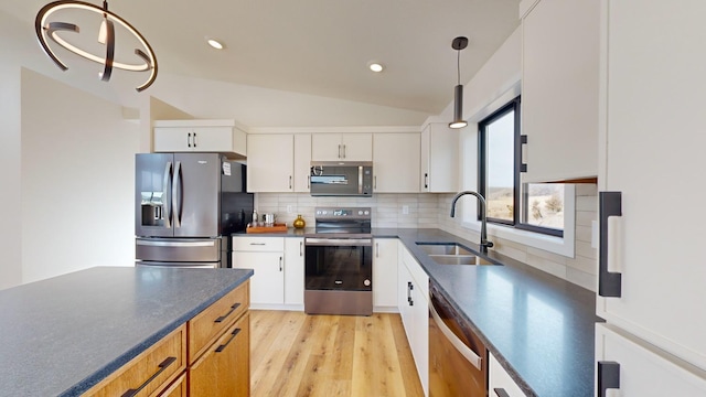 kitchen with sink, decorative light fixtures, stainless steel appliances, and white cabinets