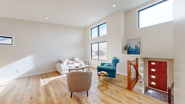 sitting room with light hardwood / wood-style floors and a high ceiling