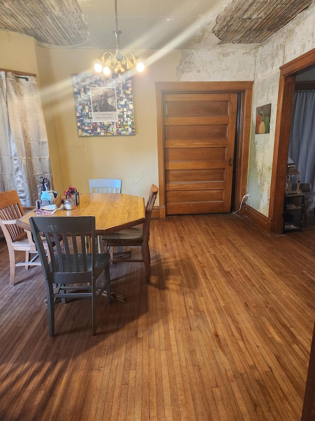 dining area featuring wood-type flooring and an inviting chandelier