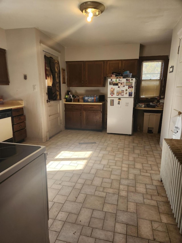 kitchen with dark brown cabinetry and white appliances