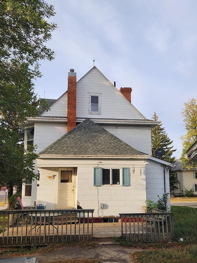 view of front of house featuring a shingled roof and a chimney